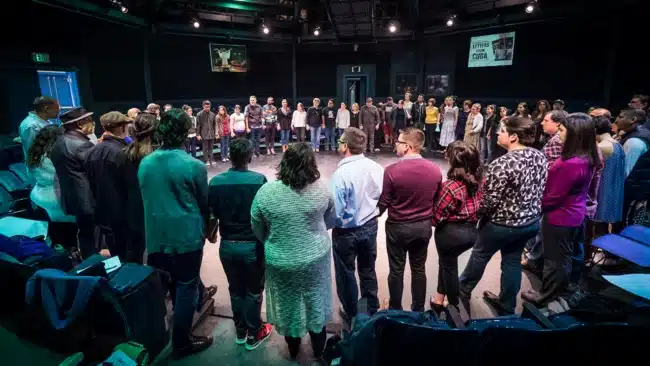 Theatre for Young Audiences - dozens of members of the latinx theatre commons standing in a large circle